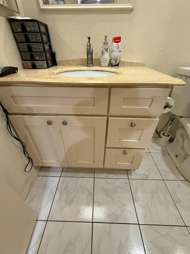 7431 Water Park Ln, Houston, TX 77086 - bathroom featuring marble finish floors, vanity, and a textured wall