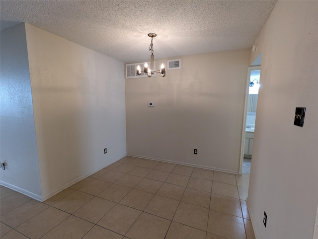 2120 El Paseo St Unit 2607, Houston, TX 77054 - unfurnished room featuring a chandelier, light tile patterned flooring, and a textured ceiling