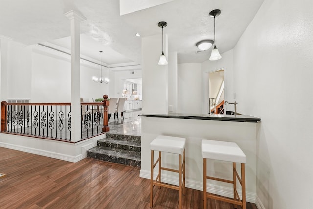12013 Naughton St, Houston, TX 77024 - bar featuring wood finished floors, a tray ceiling, a chandelier, and pendant lighting