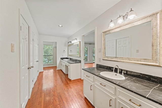 12013 Naughton St, Houston, TX 77024 - bathroom with two vanities, hardwood / wood-style flooring, and recessed lighting
