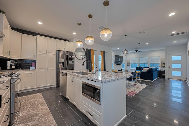 209 Blueberry St, Houston, TX 77018 - kitchen with appliances with stainless steel finishes, light stone counters, white cabinetry, recessed lighting, and ceiling fan