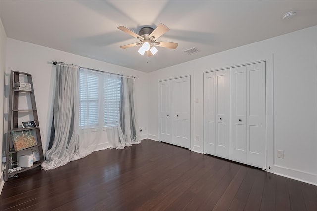 209 Blueberry St, Houston, TX 77018 - unfurnished bedroom featuring two closets, dark wood-style flooring, and ceiling fan