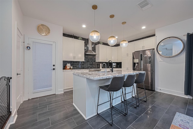209 Blueberry St, Houston, TX 77018 - kitchen with stainless steel refrigerator with ice dispenser, tasteful backsplash, white cabinetry, light stone countertops, and a kitchen island with sink