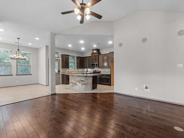 211 Cheswood Forest Pl, Montgomery, TX 77316 - unfurnished living room featuring light wood-style floors, lofted ceiling, ceiling fan, a chandelier, and recessed lighting
