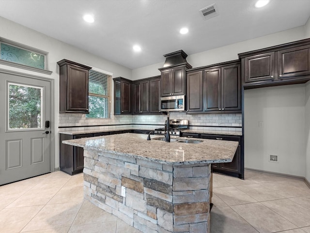 211 Cheswood Forest Pl, Montgomery, TX 77316 - kitchen with stainless steel microwave, light tile patterned floors, backsplash, and recessed lighting