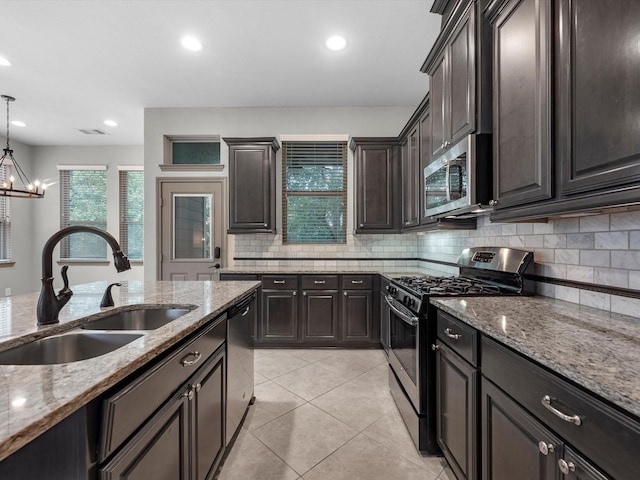 211 Cheswood Forest Pl, Montgomery, TX 77316 - kitchen featuring stainless steel appliances, backsplash, light stone countertops, light tile patterned floors, and recessed lighting