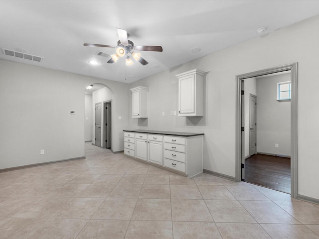 211 Cheswood Forest Pl, Montgomery, TX 77316 - kitchen featuring ceiling fan, arched walkways, light tile patterned floors, and white cabinets