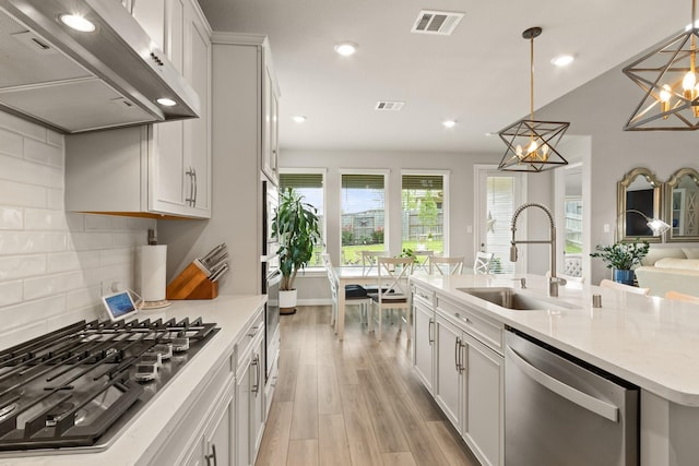 503 Highland Thicket Dr, Conroe, TX 77316 - kitchen featuring extractor fan, appliances with stainless steel finishes, light wood-style flooring, recessed lighting, and decorative backsplash