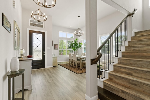 503 Highland Thicket Dr, Conroe, TX 77316 - entryway with a chandelier, stairs, light wood-style floors, and a towering ceiling