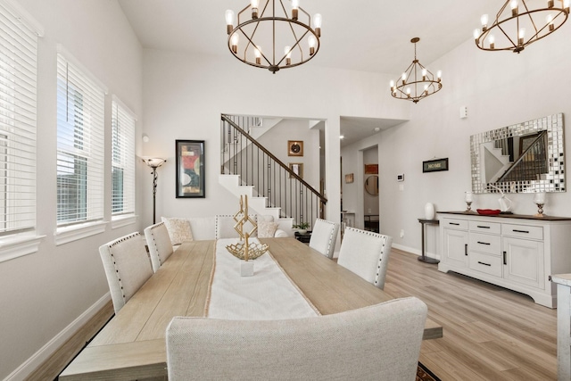 503 Highland Thicket Dr, Conroe, TX 77316 - dining room with a chandelier, light wood finished floors, stairway, and a high ceiling