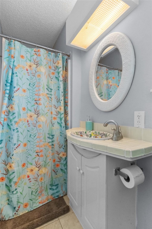 21216 Gulf Dr, Galveston, TX 77554 - full bathroom with vanity, tile patterned floors, a textured ceiling, and curtained shower