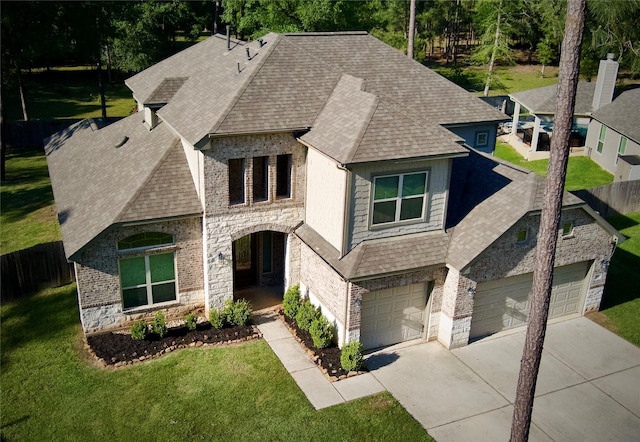 59 Beaconsfield Dr, Magnolia, TX 77355 - french country home with stone siding, roof with shingles, concrete driveway, and an attached garage