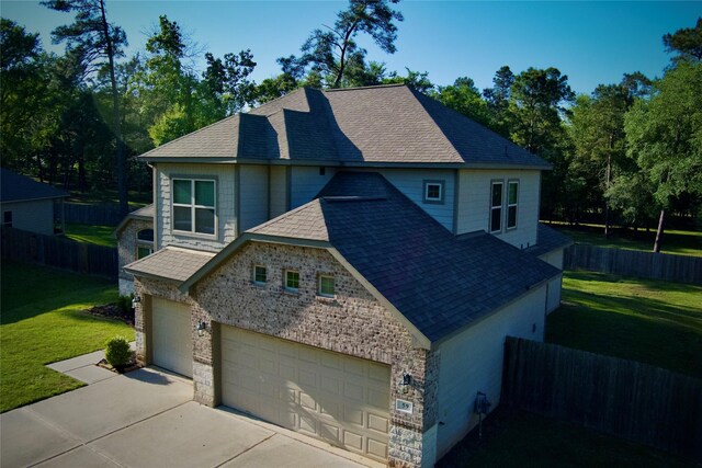 59 Beaconsfield Dr, Magnolia, TX 77355 - view of property exterior featuring driveway, a garage, a shingled roof, and stone siding