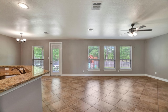 59 Beaconsfield Dr, Magnolia, TX 77355 - unfurnished living room featuring light tile patterned floors, a chandelier, ceiling fan, and a textured ceiling
