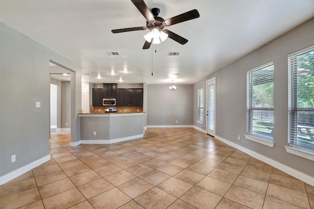 59 Beaconsfield Dr, Magnolia, TX 77355 - unfurnished living room with light tile patterned floors, a ceiling fan, and a chandelier