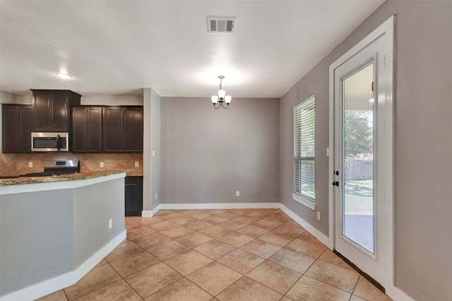 59 Beaconsfield Dr, Magnolia, TX 77355 - kitchen featuring appliances with stainless steel finishes, decorative backsplash, light tile patterned floors, and dark brown cabinetry