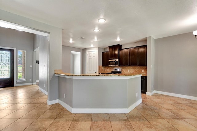 59 Beaconsfield Dr, Magnolia, TX 77355 - kitchen with appliances with stainless steel finishes, tasteful backsplash, light tile patterned flooring, and light stone countertops