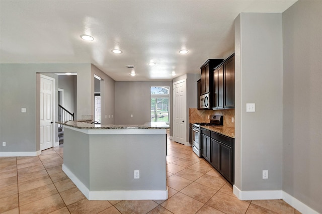59 Beaconsfield Dr, Magnolia, TX 77355 - kitchen featuring stainless steel appliances, stone counters, tasteful backsplash, light tile patterned floors, and recessed lighting