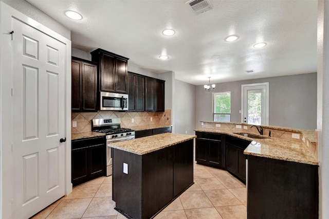 59 Beaconsfield Dr, Magnolia, TX 77355 - kitchen with stainless steel appliances, backsplash, recessed lighting, a center island, and light tile patterned floors