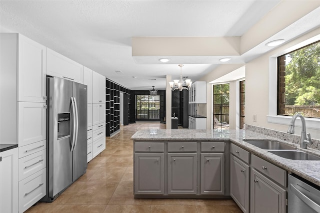 5 Cat Feet Ct, Spring, TX 77381 - kitchen featuring stainless steel appliances, gray cabinets, a chandelier, a peninsula, and light tile patterned floors