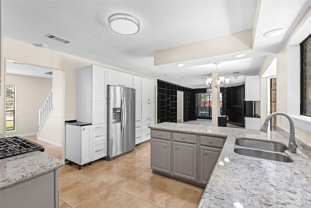 5 Cat Feet Ct, Spring, TX 77381 - kitchen with stainless steel refrigerator with ice dispenser, a chandelier, light stone counters, gray cabinetry, and recessed lighting