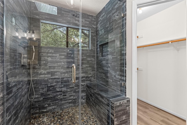 5 Cat Feet Ct, Spring, TX 77381 - full bathroom featuring a stall shower, wood finished floors, a walk in closet, and a textured ceiling