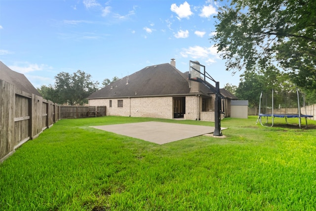 100 Anderson Ranch Ln, Friendswood, TX 77546 - rear view of house with a trampoline, a fenced backyard, a patio, and brick siding