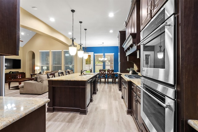 100 Anderson Ranch Ln, Friendswood, TX 77546 - kitchen featuring light wood-style flooring, dark brown cabinets, a chandelier, light stone counters, and recessed lighting