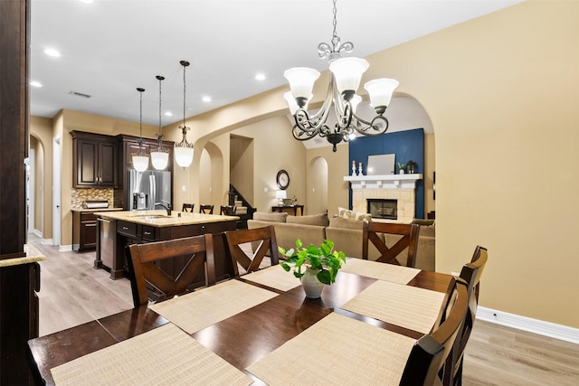 100 Anderson Ranch Ln, Friendswood, TX 77546 - dining space with arched walkways, recessed lighting, light wood-style flooring, and a chandelier