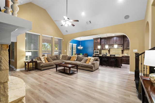 100 Anderson Ranch Ln, Friendswood, TX 77546 - living area with arched walkways, high vaulted ceiling, ceiling fan, light wood finished floors, and a chandelier
