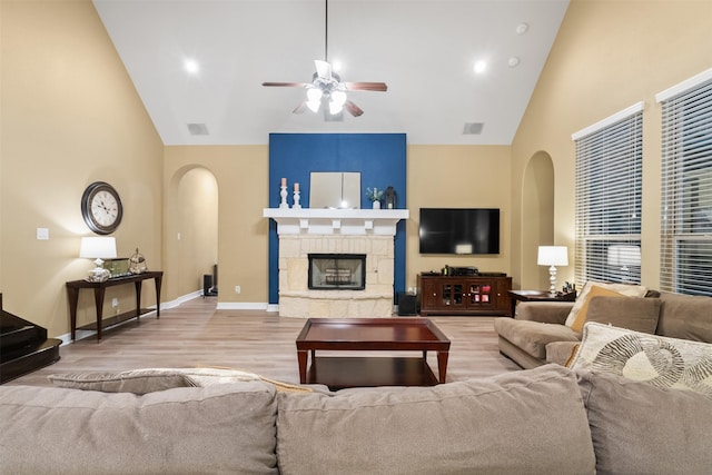 100 Anderson Ranch Ln, Friendswood, TX 77546 - living room with arched walkways, a ceiling fan, wood finished floors, high vaulted ceiling, and a tiled fireplace