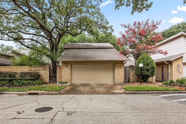 8020 Oakwood Forest Dr, Houston, TX 77040 - mid-century home with a gate, brick siding, a garage, and a shingled roof
