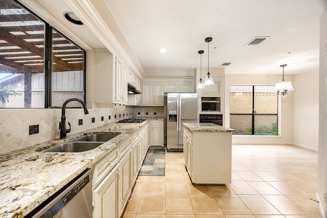 8020 Oakwood Forest Dr, Houston, TX 77040 - kitchen with appliances with stainless steel finishes, tasteful backsplash, a kitchen island, under cabinet range hood, and pendant lighting