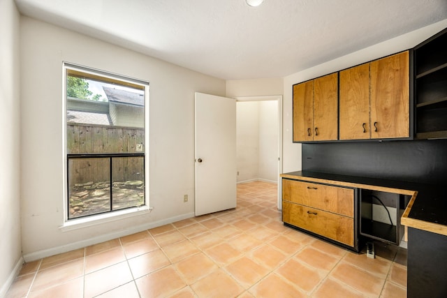 8020 Oakwood Forest Dr, Houston, TX 77040 - kitchen featuring brown cabinetry, open shelves, and light tile patterned floors