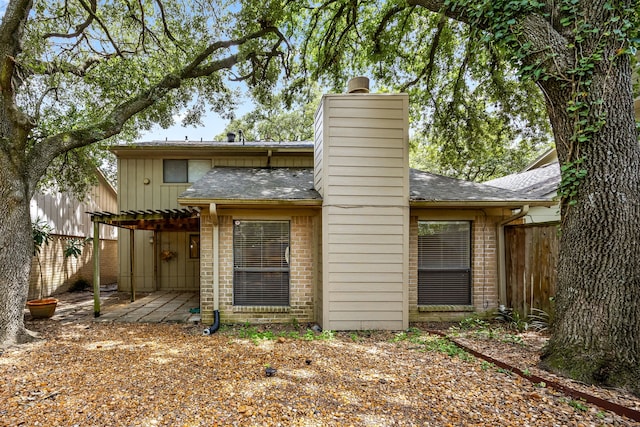 8020 Oakwood Forest Dr, Houston, TX 77040 - back of house featuring brick siding, a chimney, a patio area, a shingled roof, and a pergola