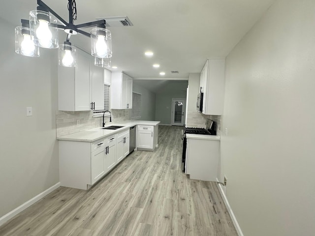 18468 Misty Wood Ln, Porter, TX 77365 - kitchen featuring appliances with stainless steel finishes, tasteful backsplash, light wood-type flooring, white cabinetry, and light countertops