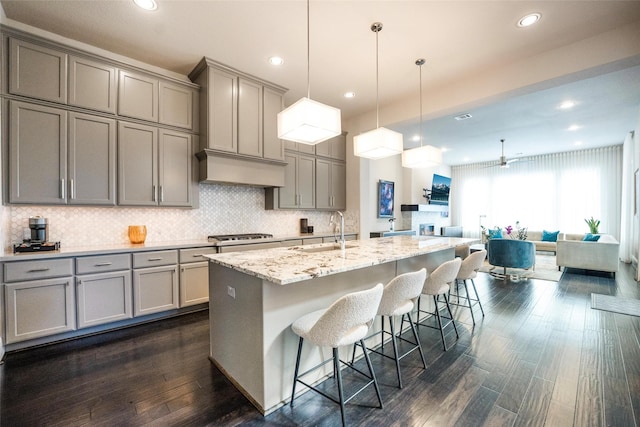 34207 Mill Creek Ct, Pinehurst, TX 77362 - kitchen featuring gray cabinetry, backsplash, dark wood-style floors, a kitchen breakfast bar, and recessed lighting