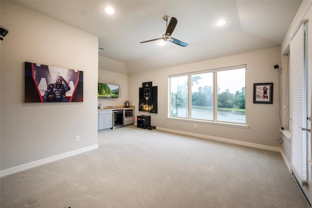 34207 Mill Creek Ct, Pinehurst, TX 77362 - unfurnished living room featuring lofted ceiling, light colored carpet, a ceiling fan, recessed lighting, and bar
