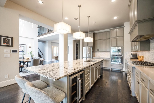 34207 Mill Creek Ct, Pinehurst, TX 77362 - kitchen with stainless steel appliances, beverage cooler, gray cabinetry, custom exhaust hood, and dark wood-style floors