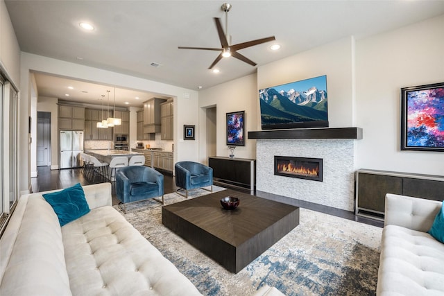 34207 Mill Creek Ct, Pinehurst, TX 77362 - living area featuring a glass covered fireplace, ceiling fan, recessed lighting, wood finished floors, and a chandelier