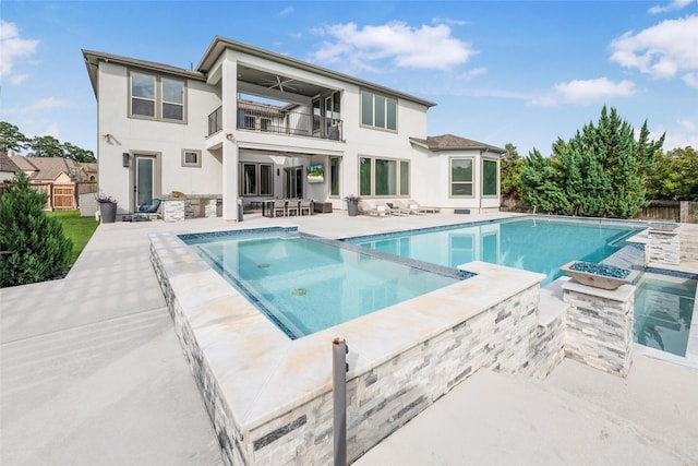 34207 Mill Creek Ct, Pinehurst, TX 77362 - rear view of house with a balcony, a patio, a pool with connected hot tub, a fenced backyard, and stucco siding