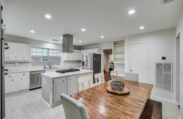 3411 Deeds Rd, Houston, TX 77084 - kitchen with stainless steel appliances, island range hood, a center island, light countertops, and white cabinets