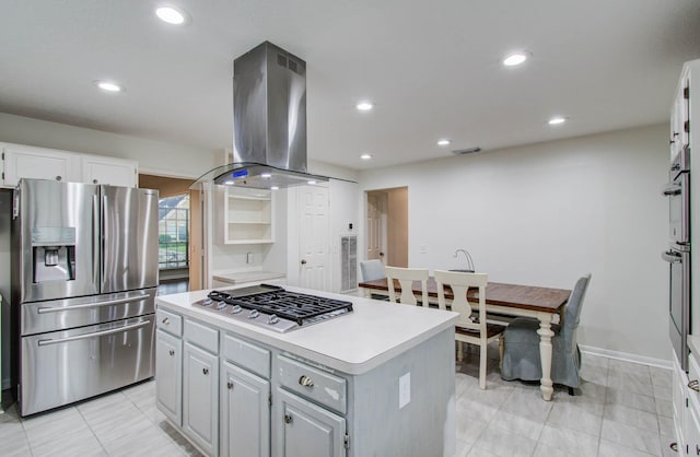 3411 Deeds Rd, Houston, TX 77084 - kitchen featuring appliances with stainless steel finishes, island exhaust hood, a center island, light countertops, and white cabinetry