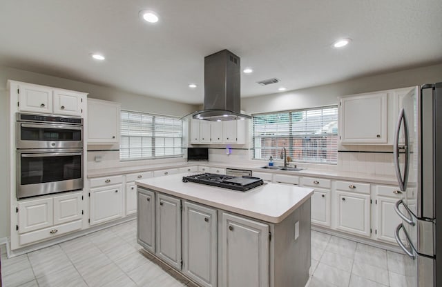 3411 Deeds Rd, Houston, TX 77084 - kitchen featuring stainless steel appliances, island range hood, plenty of natural light, backsplash, and recessed lighting