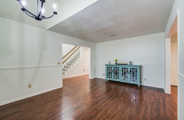 3411 Deeds Rd, Houston, TX 77084 - unfurnished living room featuring wood finished floors, a chandelier, stairs, and a textured ceiling