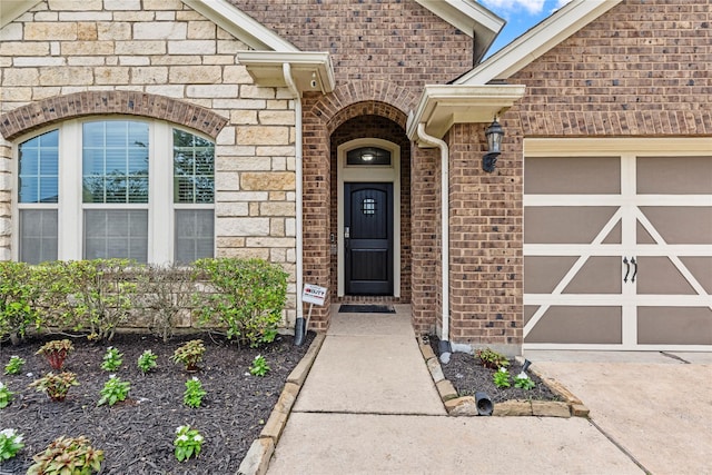 19647 Travis Cannon Ln, Richmond, TX 77407 - property entrance featuring an attached garage, brick siding, stone siding, and driveway