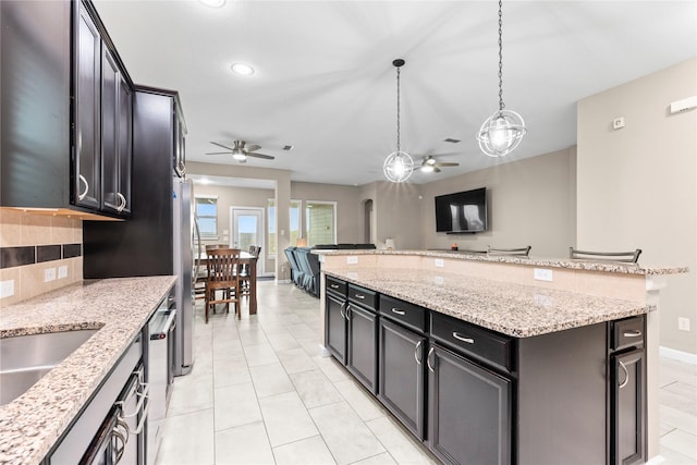 19647 Travis Cannon Ln, Richmond, TX 77407 - kitchen featuring a ceiling fan, stainless steel appliances, a kitchen island, decorative light fixtures, and recessed lighting