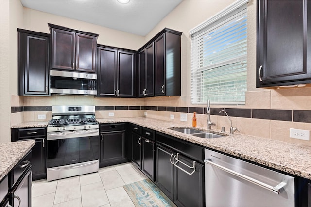 19647 Travis Cannon Ln, Richmond, TX 77407 - kitchen featuring appliances with stainless steel finishes, decorative backsplash, light stone countertops, and light tile patterned floors