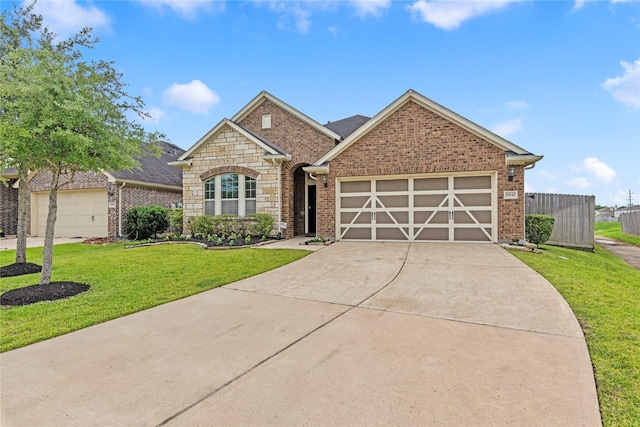 19647 Travis Cannon Ln, Richmond, TX 77407 - view of front of property featuring a garage, concrete driveway, brick siding, and stone siding