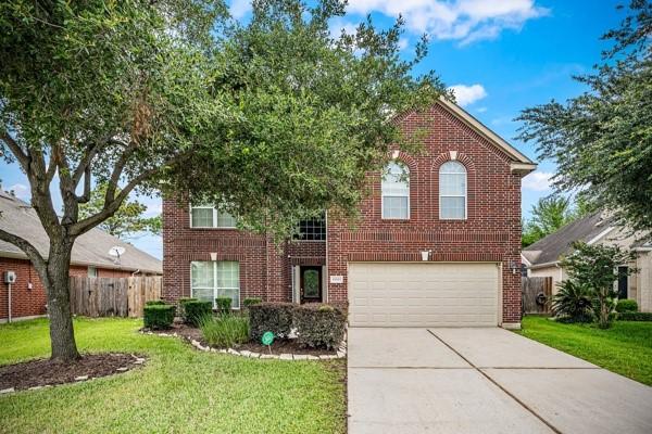 15323 Southwood Trace Ln, Houston, TX 77049 - traditional-style home with driveway, a garage, and brick siding